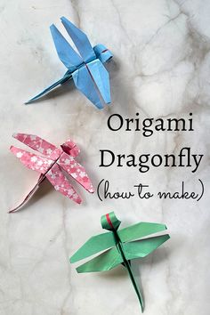 three origami dragonflys on a marble surface