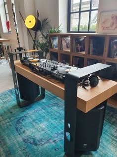 a table that has some electronic equipment on top of it in a room with bookshelves