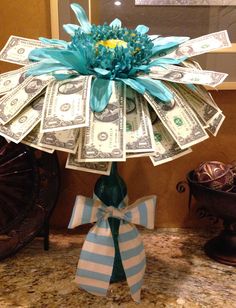a bouquet made out of dollar bills sitting on top of a counter