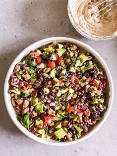 a white bowl filled with salad next to a fork