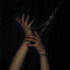 two hands are chained to each other with chains on their wrists, and one hand is in the air