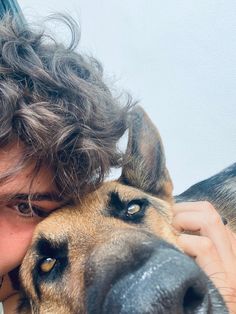 a young man is hugging his dog's face