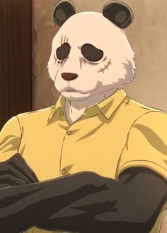 a panda bear dressed in yellow shirt and black gloves standing next to a wall with his arms crossed