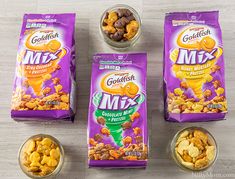 three bags of goldfish mix sitting on top of a table next to two bowls