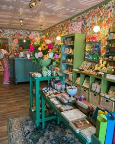 the inside of a flower shop filled with lots of books and flowers in vases