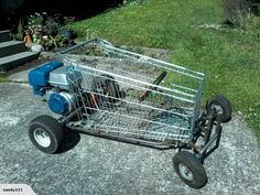 a shopping cart sitting on top of a cement slab next to grass and flowers in the background