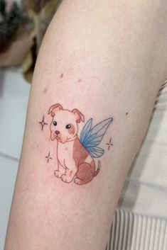 a small dog with a blue angel tattoo on its arm