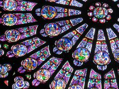 a very large stained glass window in a church with many colors and designs on it