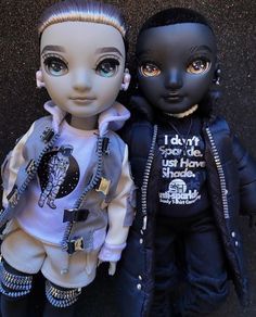 two dolls are posed next to each other