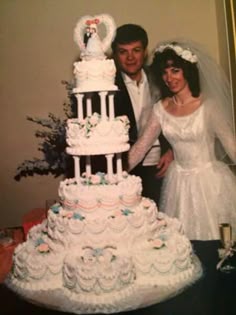a man and woman standing next to a wedding cake