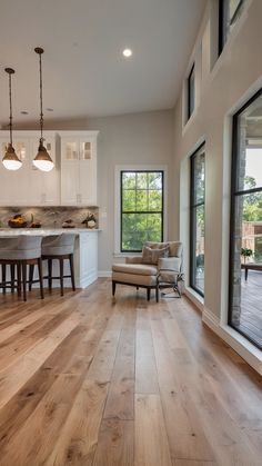 an open kitchen and living room with hardwood floors