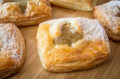 several pastries sitting on top of a wooden cutting board