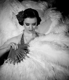 a woman sitting in a chair holding a fan