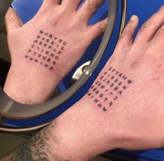two people with tattoos on their hands and one has the words written in different languages
