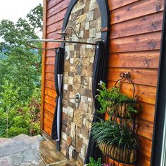 an outdoor shower with plants on the outside