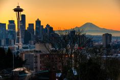the seattle skyline at sunset, with space needle in the foreground and mt rainier in the background
