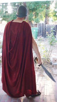 a man in a red cape holding a large knife