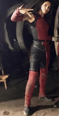 two people standing next to each other wearing red and black outfits