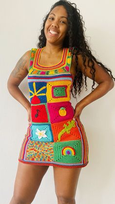 a woman in a colorful crochet dress poses for the camera with her hands on her hips