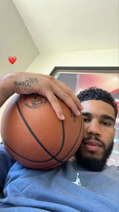 a man holding a basketball in his lap