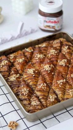 a pan filled with food sitting on top of a table next to a jar of peanut butter