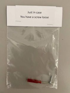 a plastic bag with a toothbrush in it and a sign that says, just in case you have a screw loose