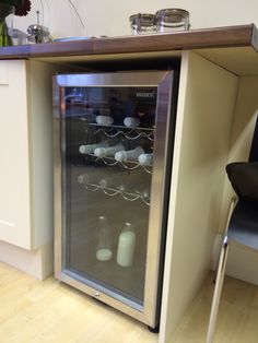 an empty wine cooler sitting in the middle of a kitchen