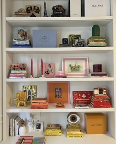 a white book shelf filled with lots of books and other items on top of it