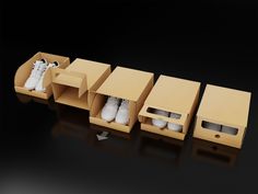 an open cardboard box with three pairs of white shoes in it and two boxes on the side