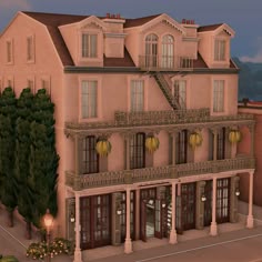 a large pink building with many windows and balconies on the second floor is lit up at night