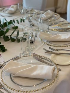 the table is set with silverware and place settings
