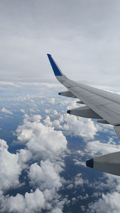 the wing of an airplane flying over clouds