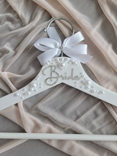 a white wooden hanger with the word bride written on it and a bow at the top