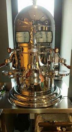 a silver clock sitting on top of a metal table