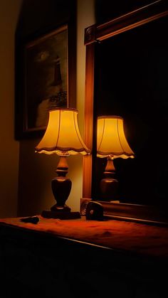 two lamps sitting on top of a table next to a mirror
