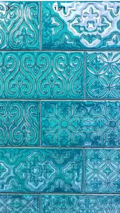 a blue tile wall with an intricate design on the top and bottom half of it