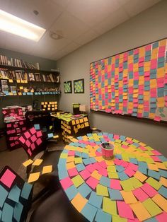 an office with colorful sticky notes on the walls and tables in front of bookshelves