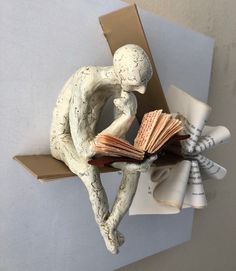 a small figurine sitting on top of an open book
