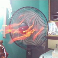 a fan that is on top of a table with fire coming out of the front