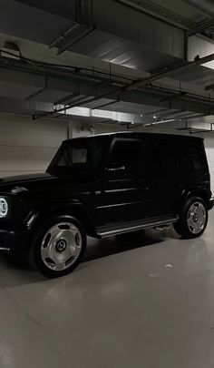 a black suv is parked in an empty parking garage with no one around or looking at it