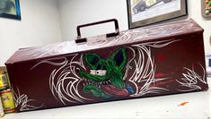 an old suitcase painted with the image of a green monster on it's side