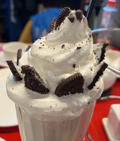 an ice cream sundae with oreo cookies on top and whipped cream in the middle