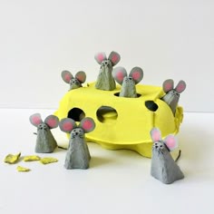 some paper mice are standing in front of a piece of yellow cardboard that has been cut out