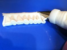 a toothbrush being used to brush the teeth on a blue surface with a white plastic tube