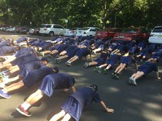 a group of young men laying on top of each other in the middle of a parking lot