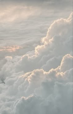 an airplane is flying high in the clouds