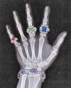 a hand with three different colored jewels on it's fingers and two other jeweled bracelets attached to the wrist