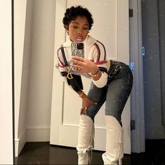 a woman taking a selfie in front of a door with her cell phone and boots