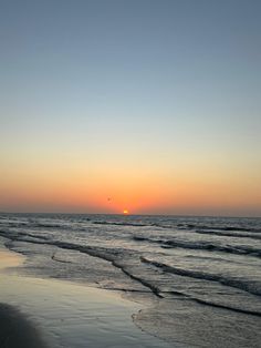 the sun is setting over the ocean at the beach
