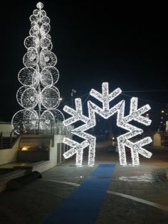 an outdoor christmas display with lights and snowflakes